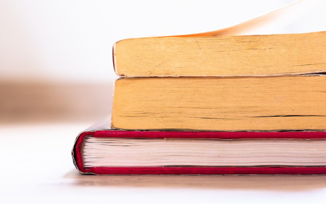 A side view of a stack of three books.