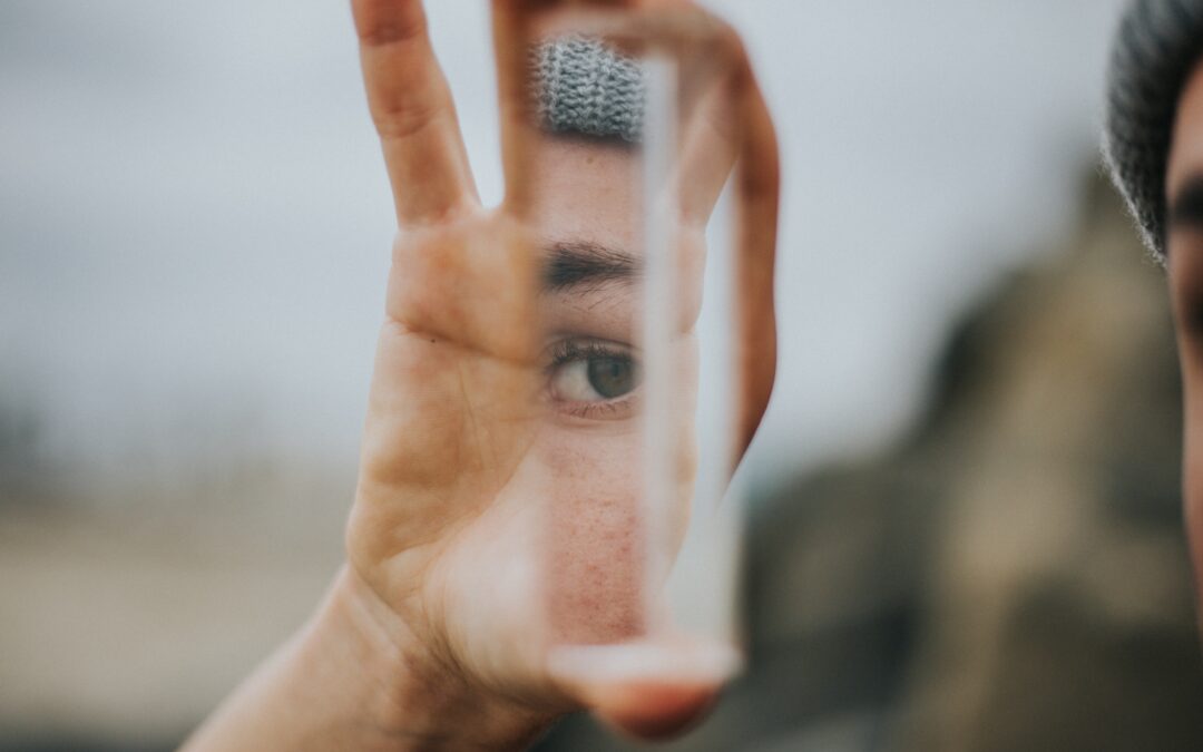 A mans reflection in a broken piece of glass